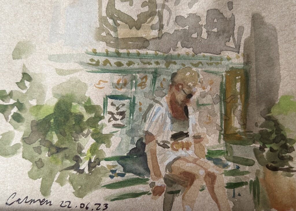 Watercolour Plein air Portrait of Carmen at the Museo Sorolla gardens. A blonde woman sitting in front of a tiled wall, surrounded by gardens. Blonde woman dressed in white shorts and striped shirt, wearing sunglasses. By Maria Pena, Artist and Illustrator. Also known as Maria de Los Angeles Pena. #Storyboarderau #storyboarder